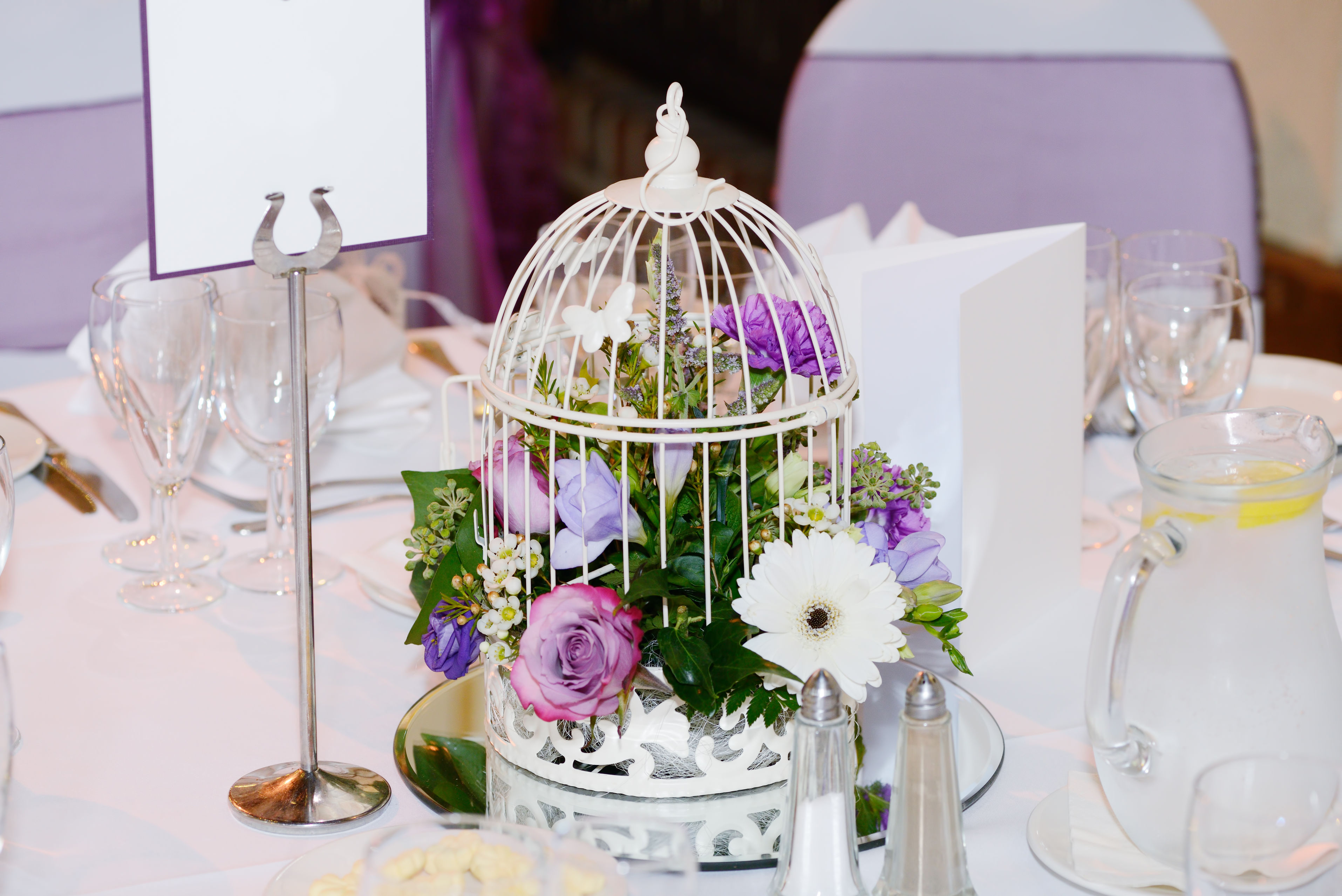 bouquet blanc et violet dans une cage blanche